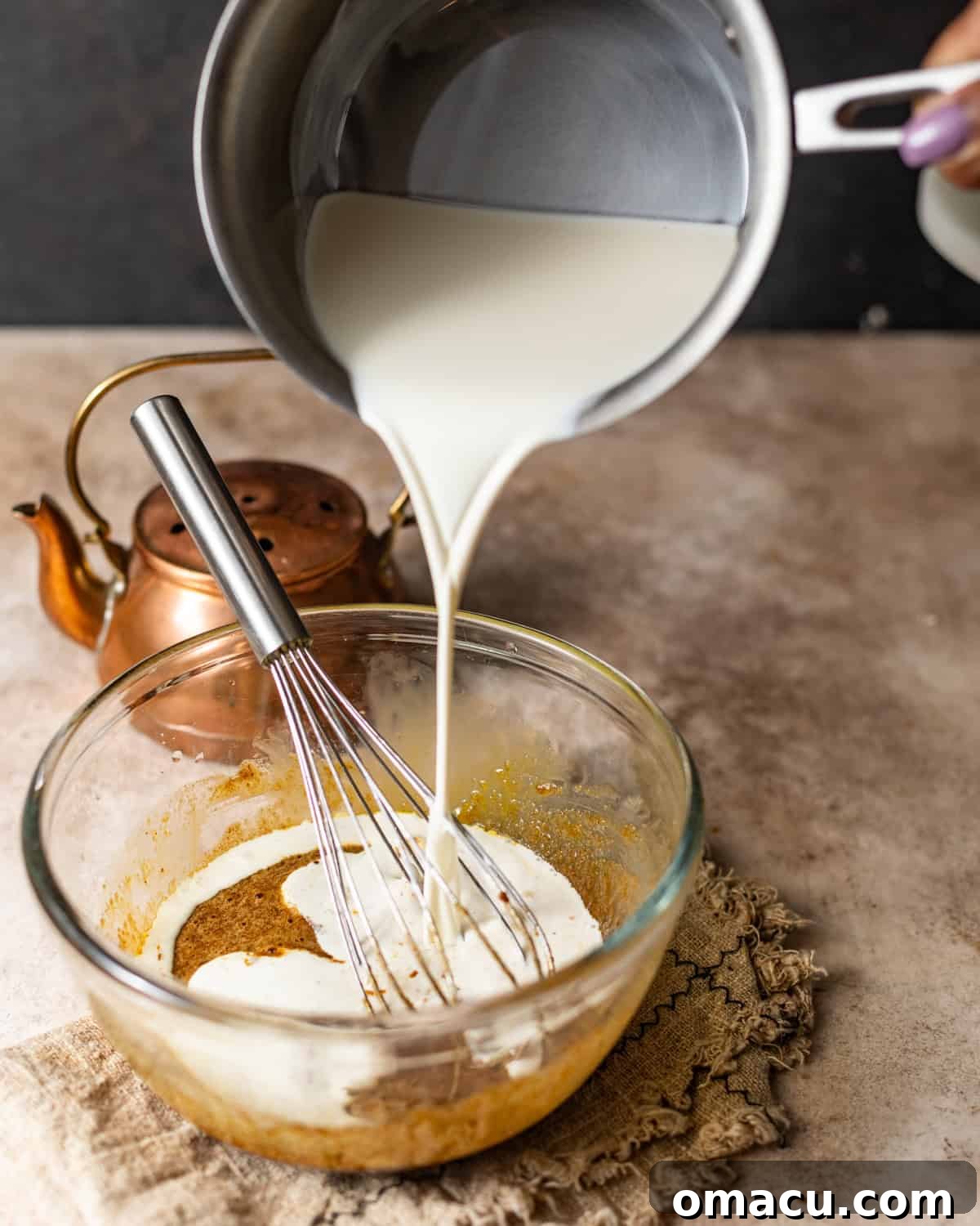 heavy cream being poured into the egg yolk mixture.
