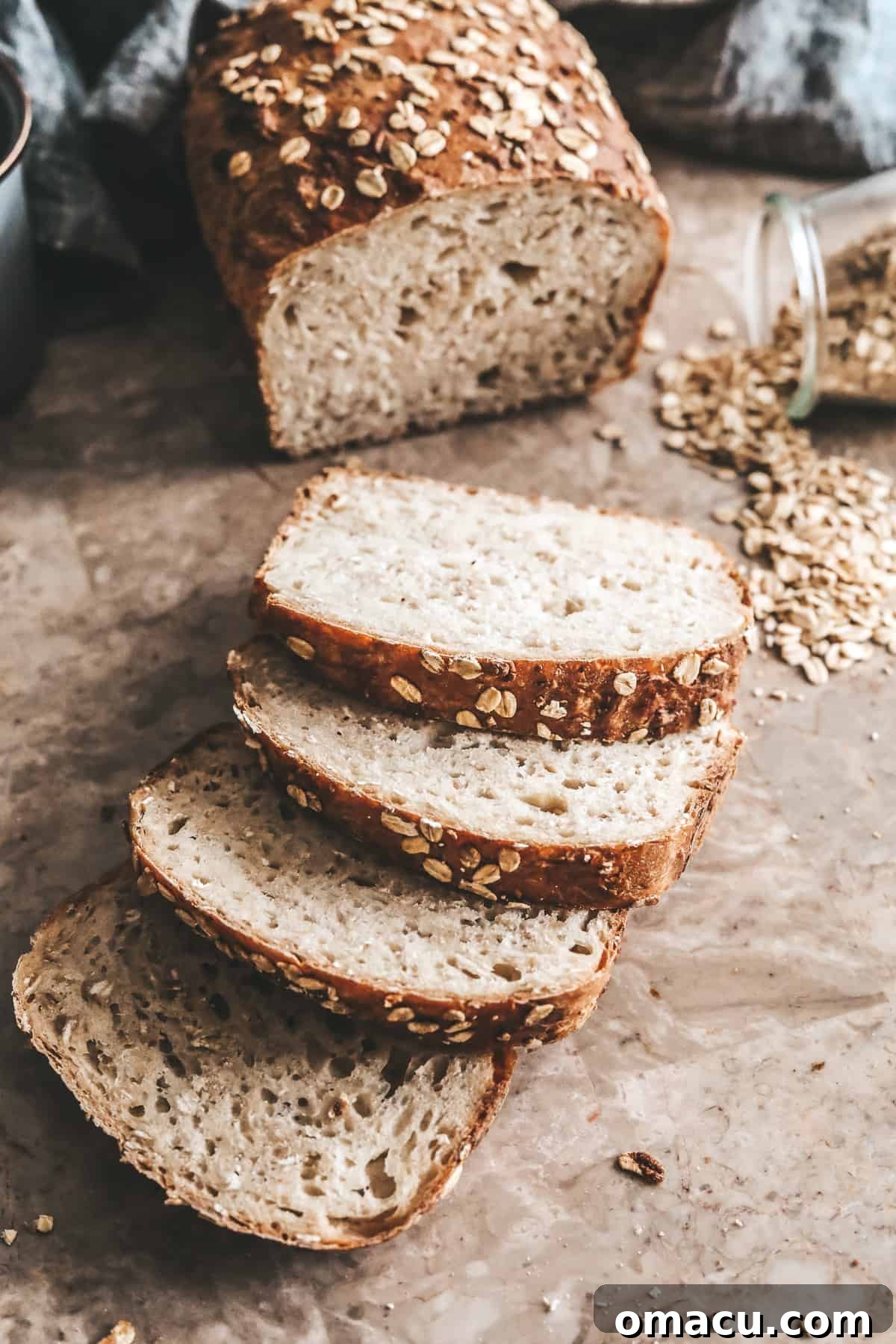 Pieces of golden-brown honey oat bread on a marble table, showcasing its delicious texture.
