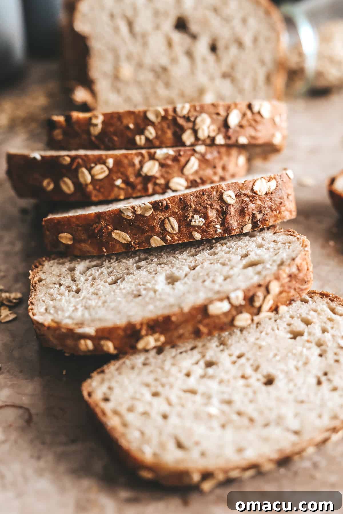 A close-up of the perfectly textured crumb of Honey Oat Bread, highlighting the oats.