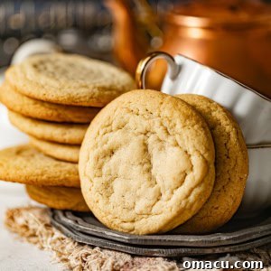 chocolate chipless cookies on a plate with two teacups.