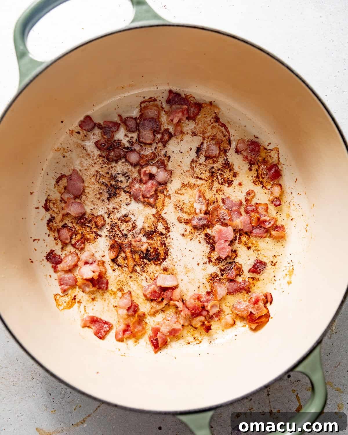 bacon in a large pot cut into bits and cooked until crispy.