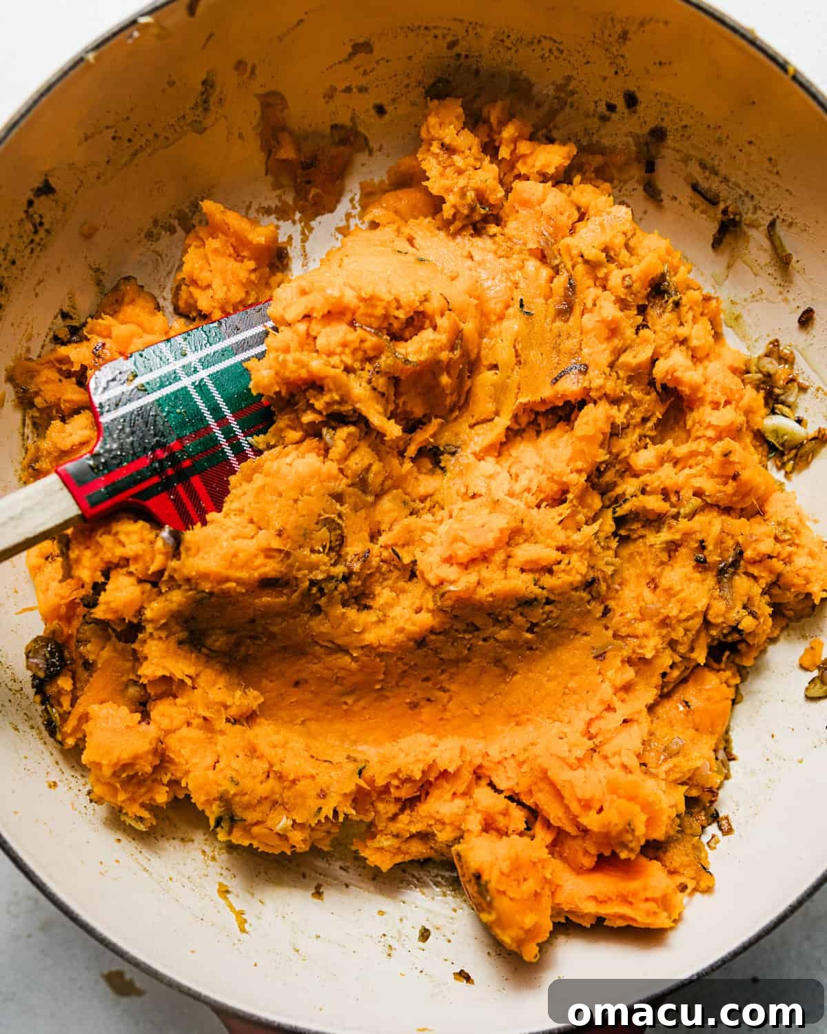 Mashed sweet potatoes mixed in with the shallot and herb mixture, ready for the baking dish.