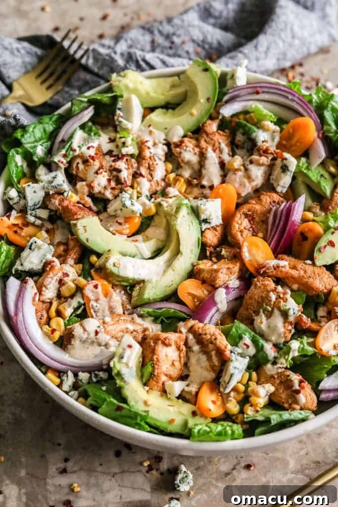 A bowl of fresh Cajun Chicken Caesar Salad with a generous drizzle of dressing