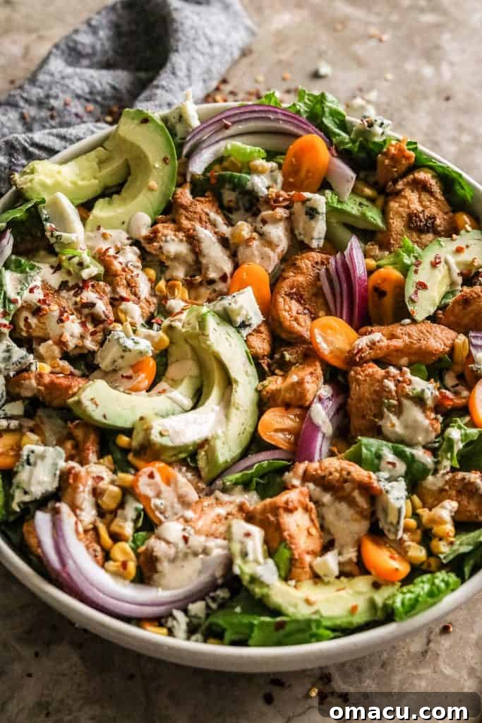 Cooked Cajun chicken breast cubes in a skillet, ready for the salad
