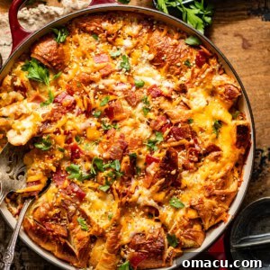 Croissant breakfast casserole in a deep round skillet, topped with parsley.