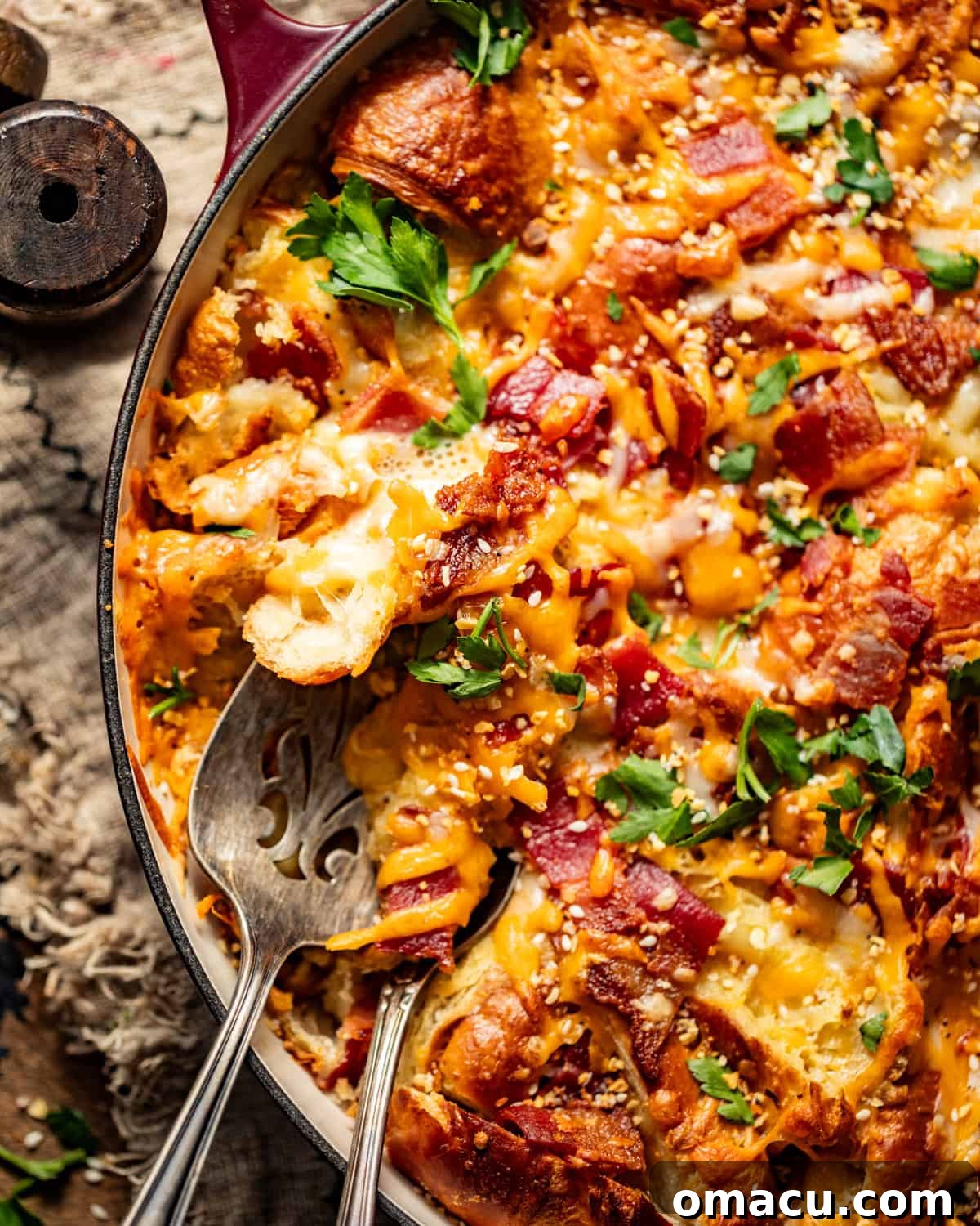 Close-up view of the savory croissant breakfast casserole, showing the golden-brown crust and melted cheese.