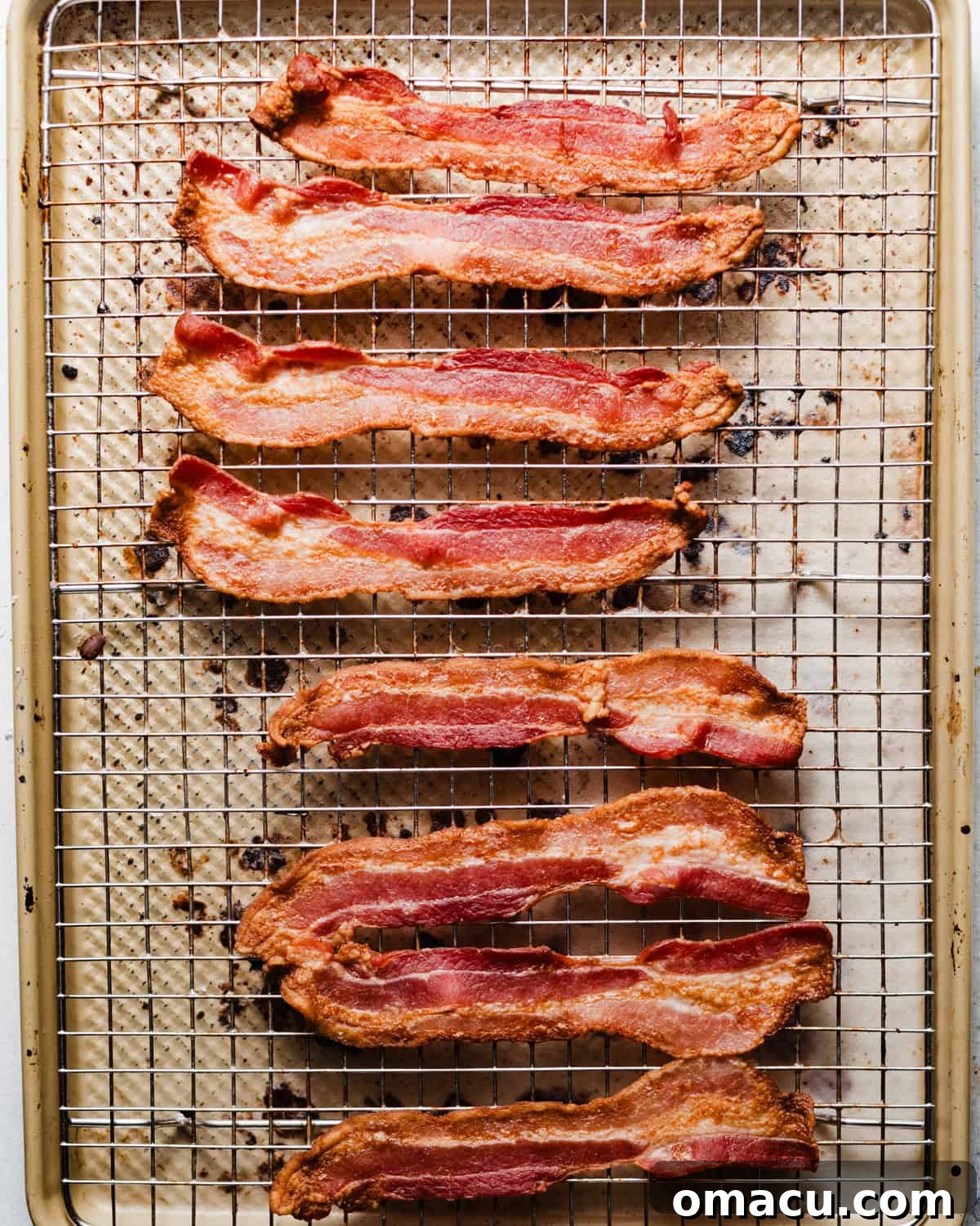 Crispy bacon strips cooling on a wire rack after being baked.