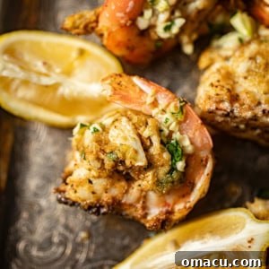 Beautifully baked crab stuffed shrimp on a silver platter, garnished with fresh lemon wedges, ready to be served as an impressive appetizer.