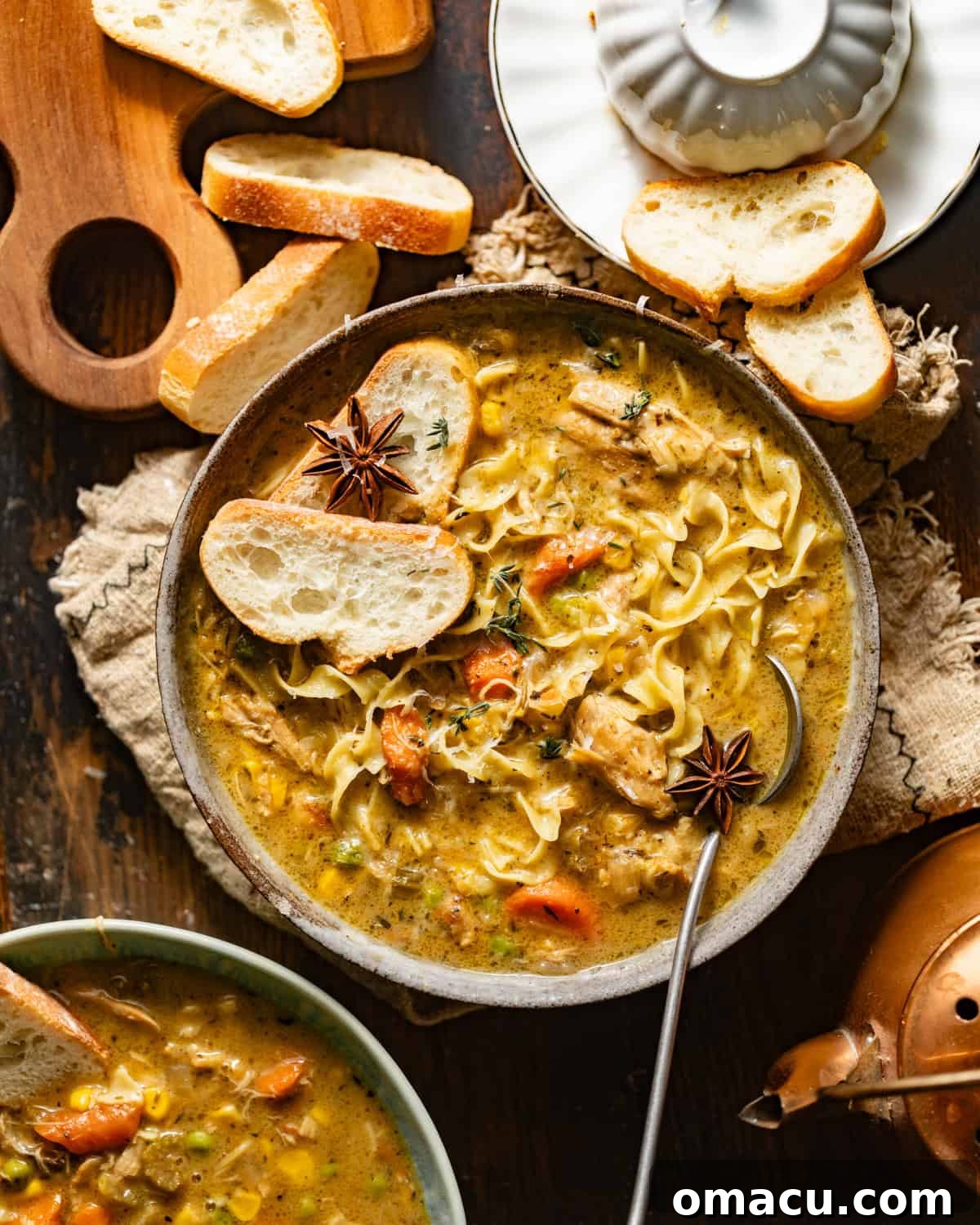 Creamy Dutch oven chicken noodle soup in a rustic bowl with a spoon, ready to be enjoyed.