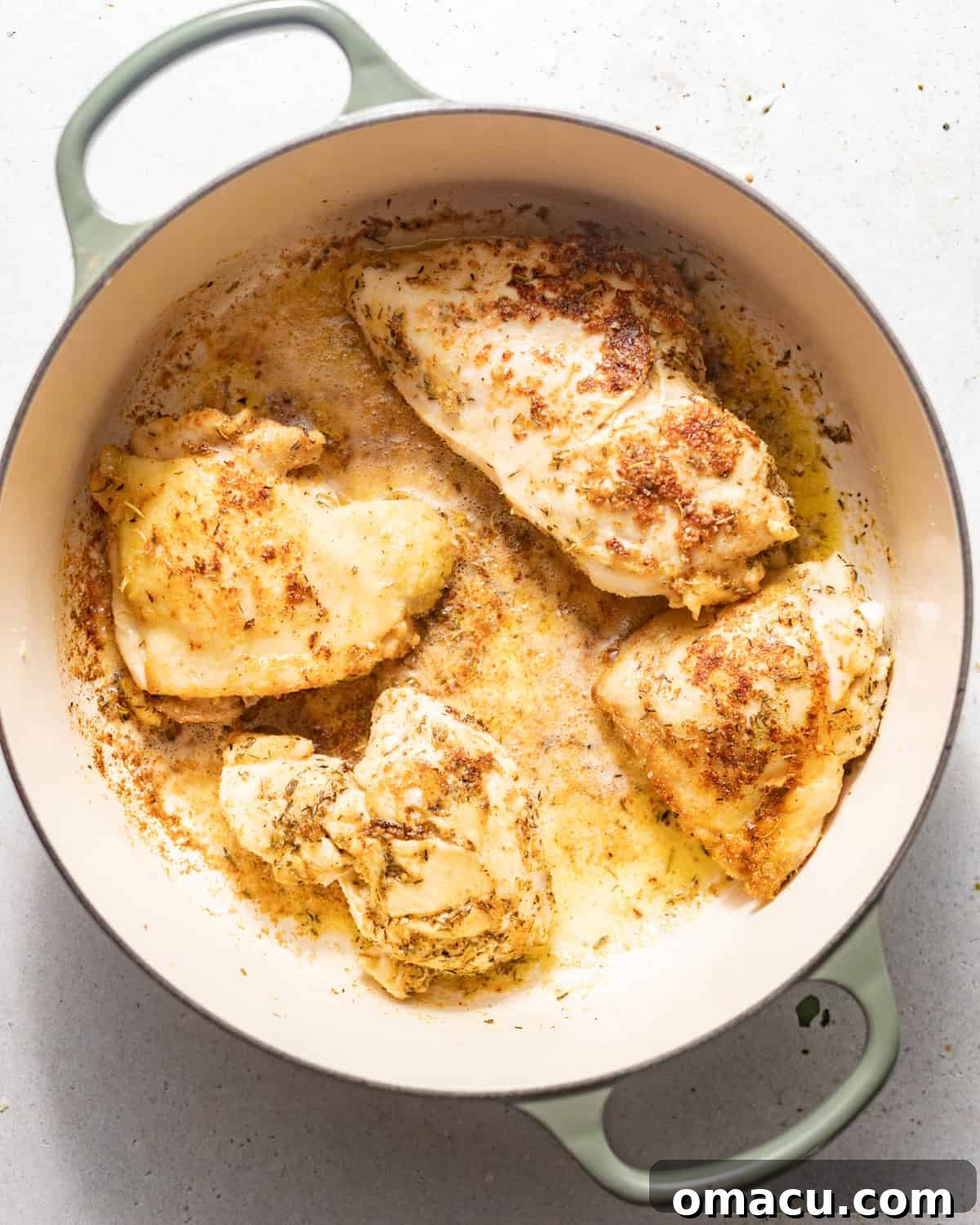 Chicken thighs being seared to a golden brown in a large Dutch oven, creating a flavorful base.
