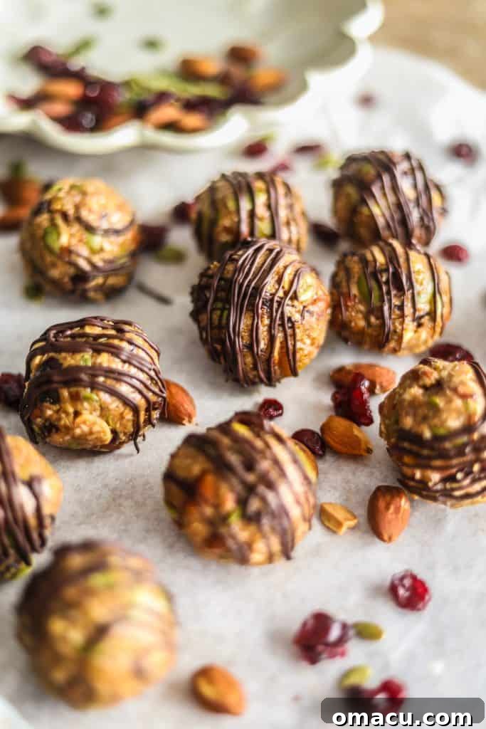 A close-up of a rustic wooden bowl filled with various mixed fruit and nut energy bites, featuring a rich, textured appearance.