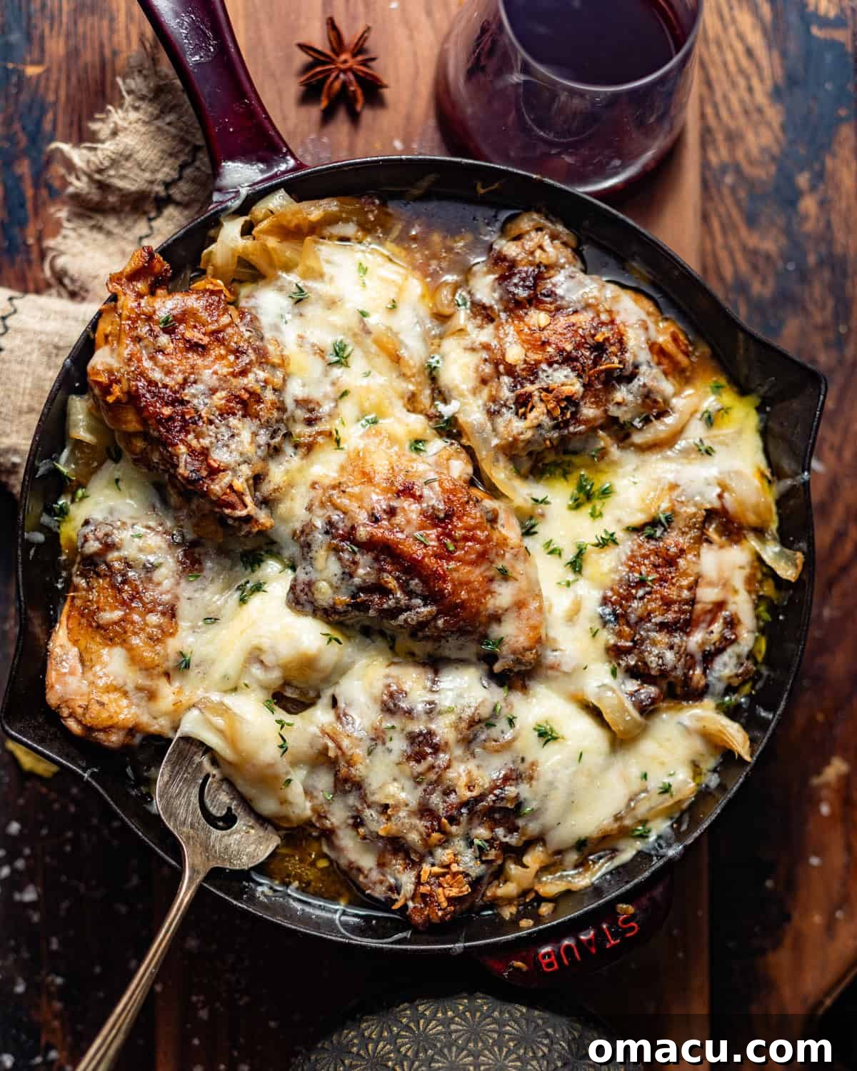crock pot french onion chicken in a large skillet topped with melted gruyere cheese and thyme.