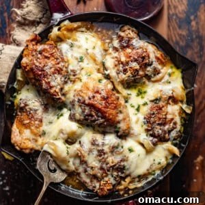 crock pot french onion chicken in a large skillet topped with melted gruyere cheese and thyme.