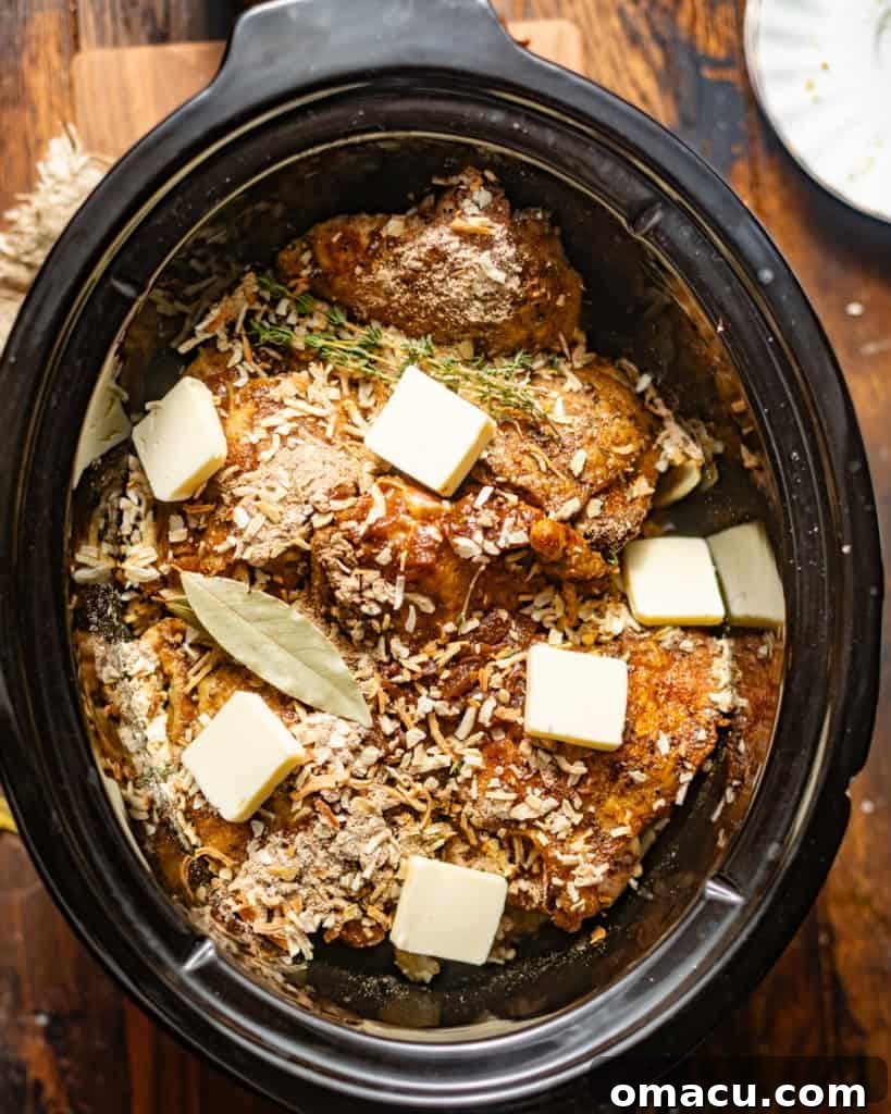 chicken thighs, onions, french onion soup mix, condensed french onion soup, butter, and fresh herbs combined in a crock pot.