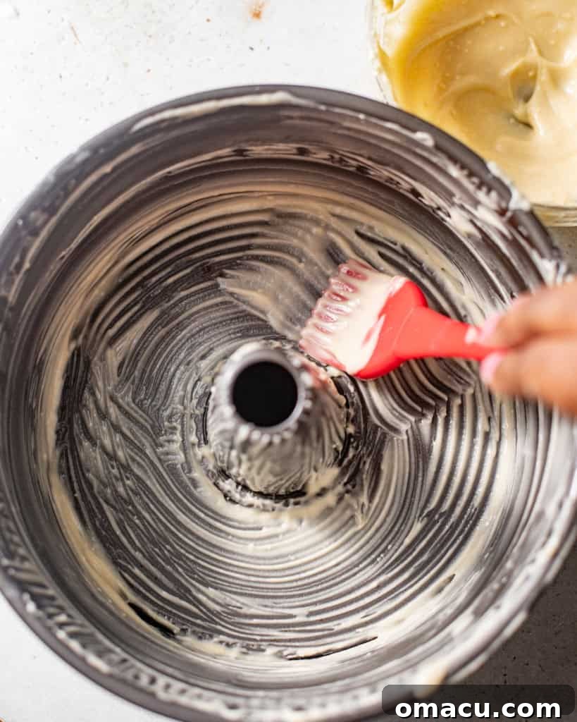 Cake release mixture spread generously across the interior of a tube pan using a pastry brush, ensuring full coverage.
