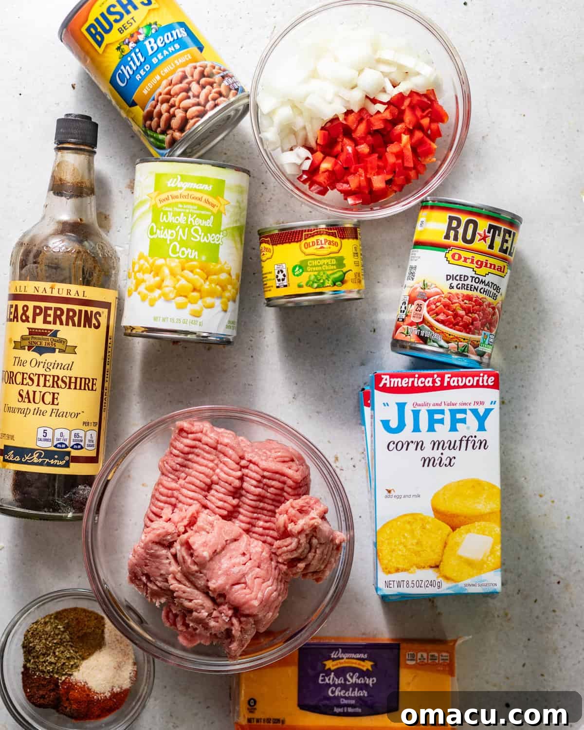 A selection of fresh and canned ingredients laid out on a white surface, ready to make cowboy cornbread casserole.