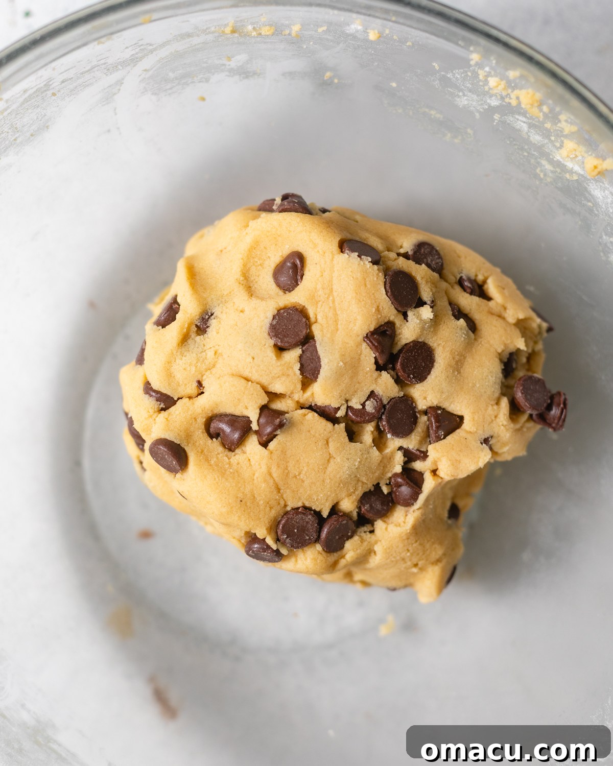 Chocolate chip cookie dough with visible chocolate chips in a bowl, after dry ingredients and chips have been folded in.