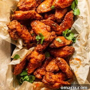 Hot honey chicken wings in a basket, garnished with parsley.