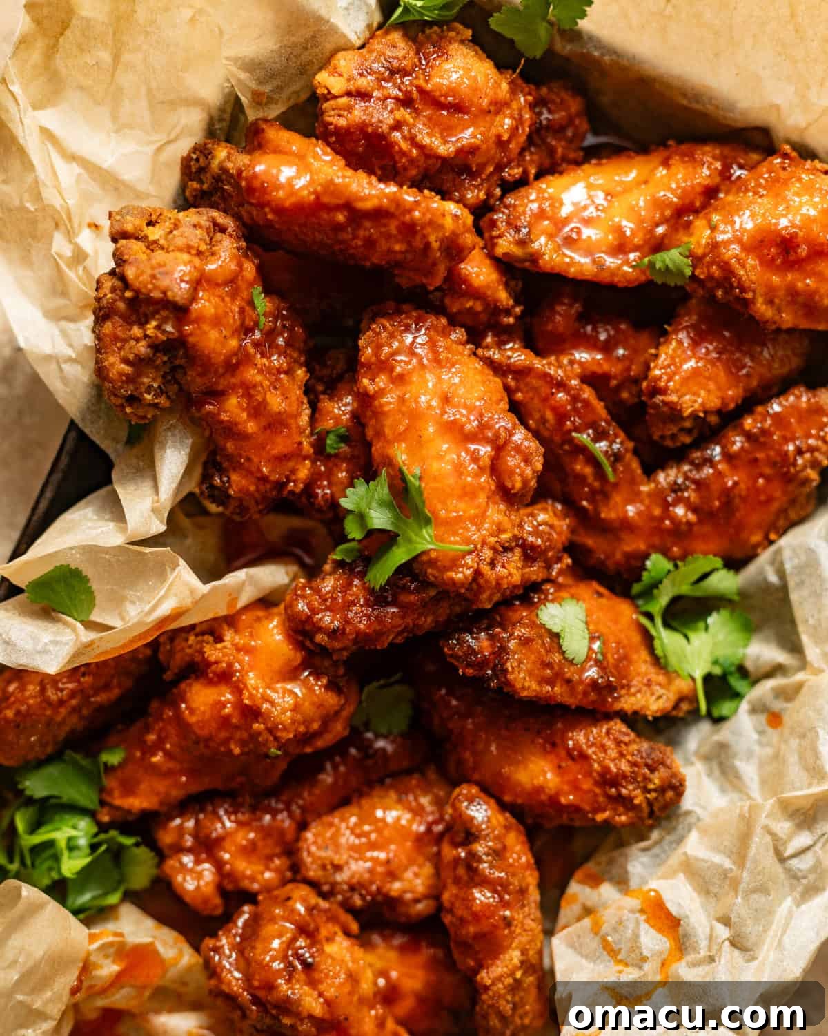 Close-up of crispy hot honey chicken wings in a serving basket.
