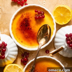 Lemon creme brulee in ramekins with red currants garnished on top.