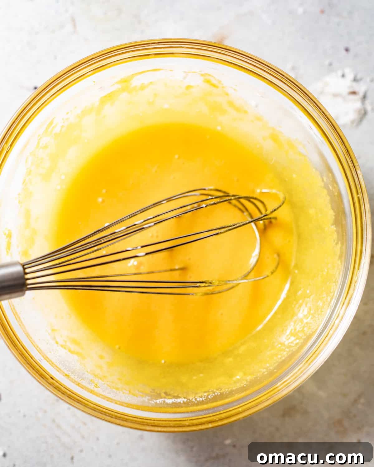 Egg yolks, granulated sugar, vibrant lemon extract, and fragrant lemon zest whisked together in a mixing bowl until light and fluffy.