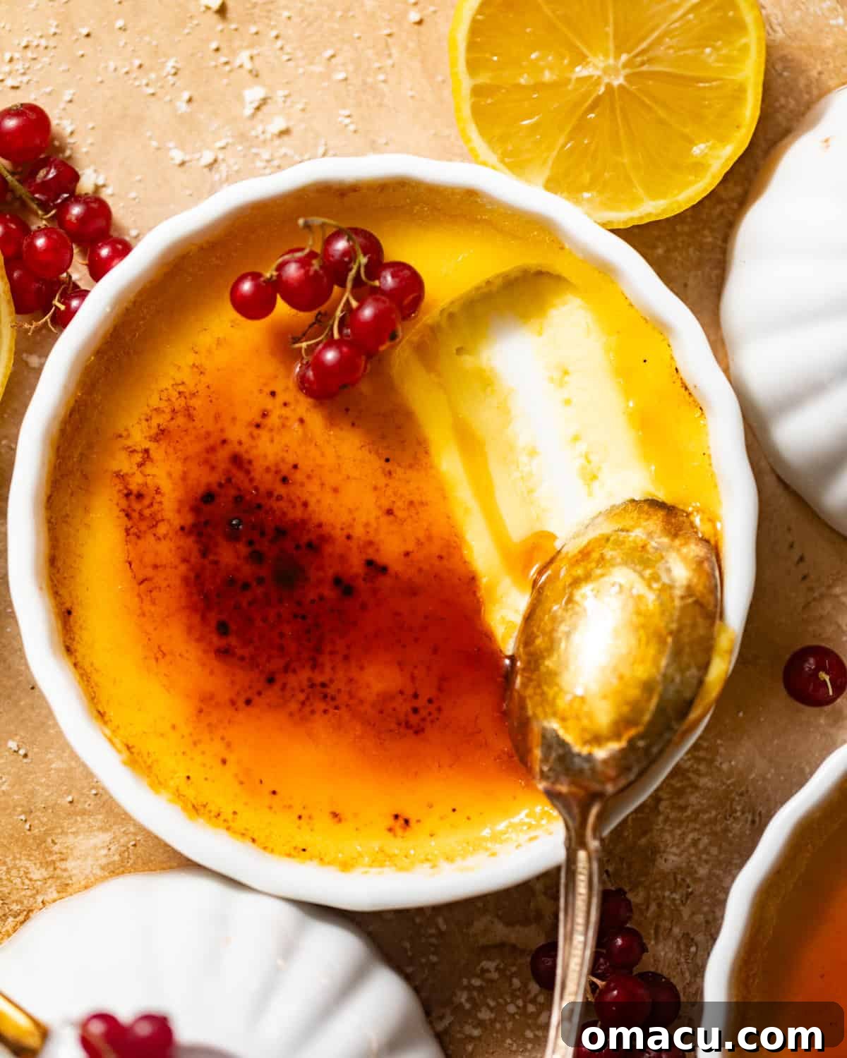 A spoon gracefully breaking through the caramelized sugar topping of a lemon creme brulee, revealing the creamy custard beneath.