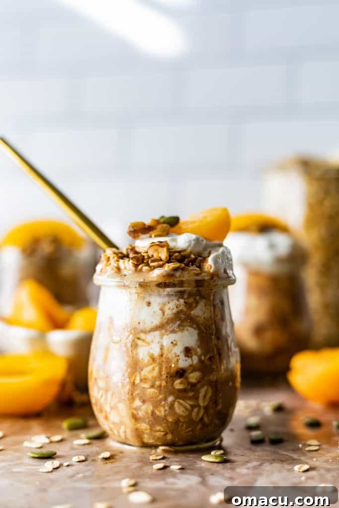 Overhead shot of a jar of Peach Cobbler Overnight Oats with fresh peach slices and a spoon.