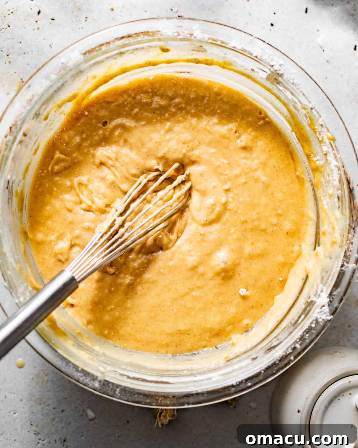 Wet ingredients for coffee cake muffins whisked together in a bowl.
