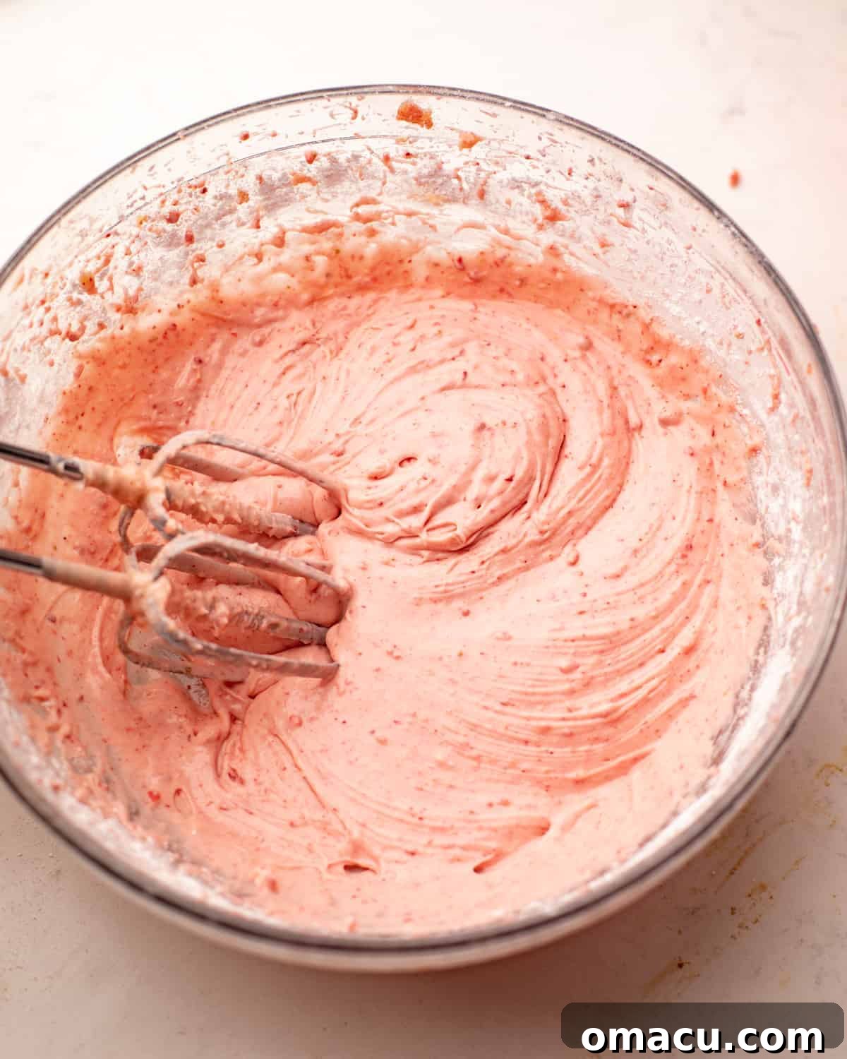 Fluffy strawberry white chocolate mascarpone frosting in a mixing bowl, perfectly whipped and ready for decorating.