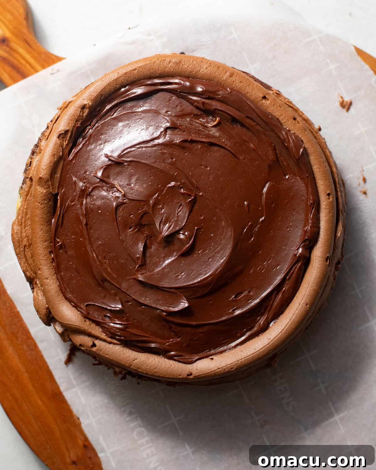 A chocolate cake layer topped with creamy frosting, a piped border, and a generous filling of rich chocolate ganache.