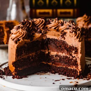 triple chocolate cake on a white plate with a large piece cut out to show the inside of the cake.