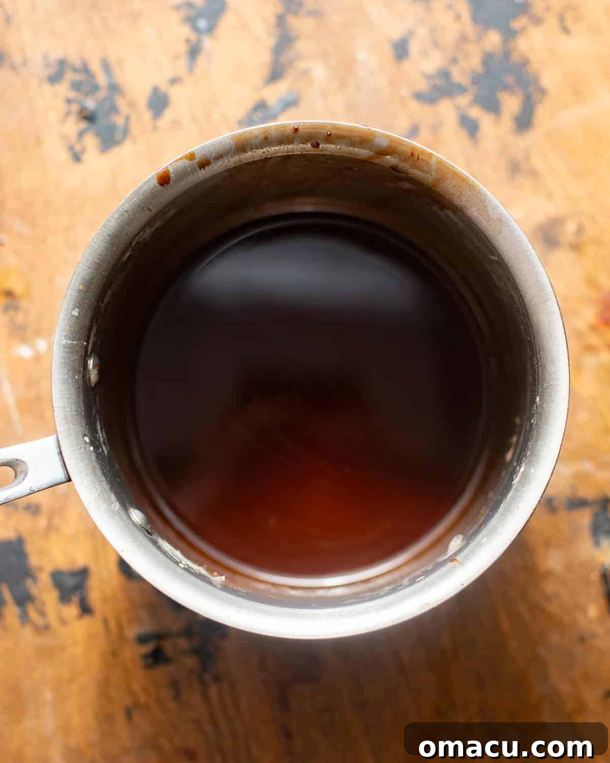 Chocolate syrup cake soak simmering in a small saucepan on the stove.