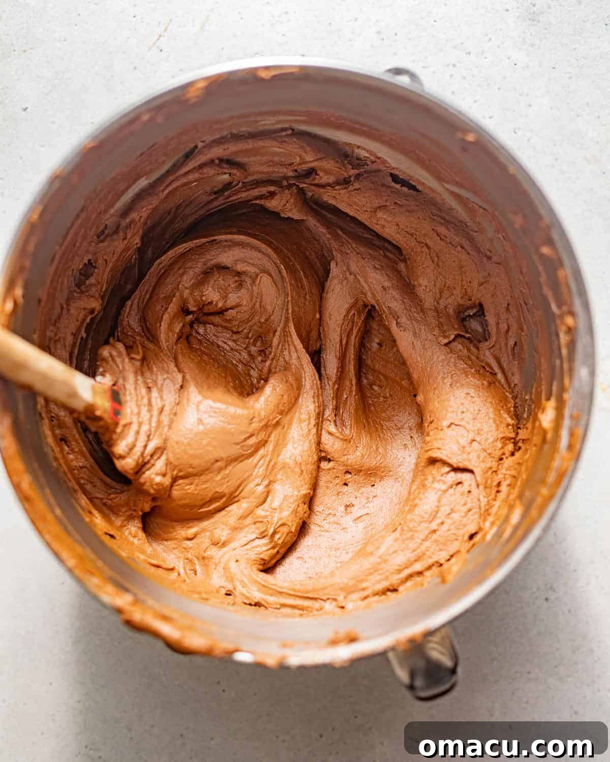 Smooth and creamy chocolate cream cheese frosting in a mixing bowl, ready for application.