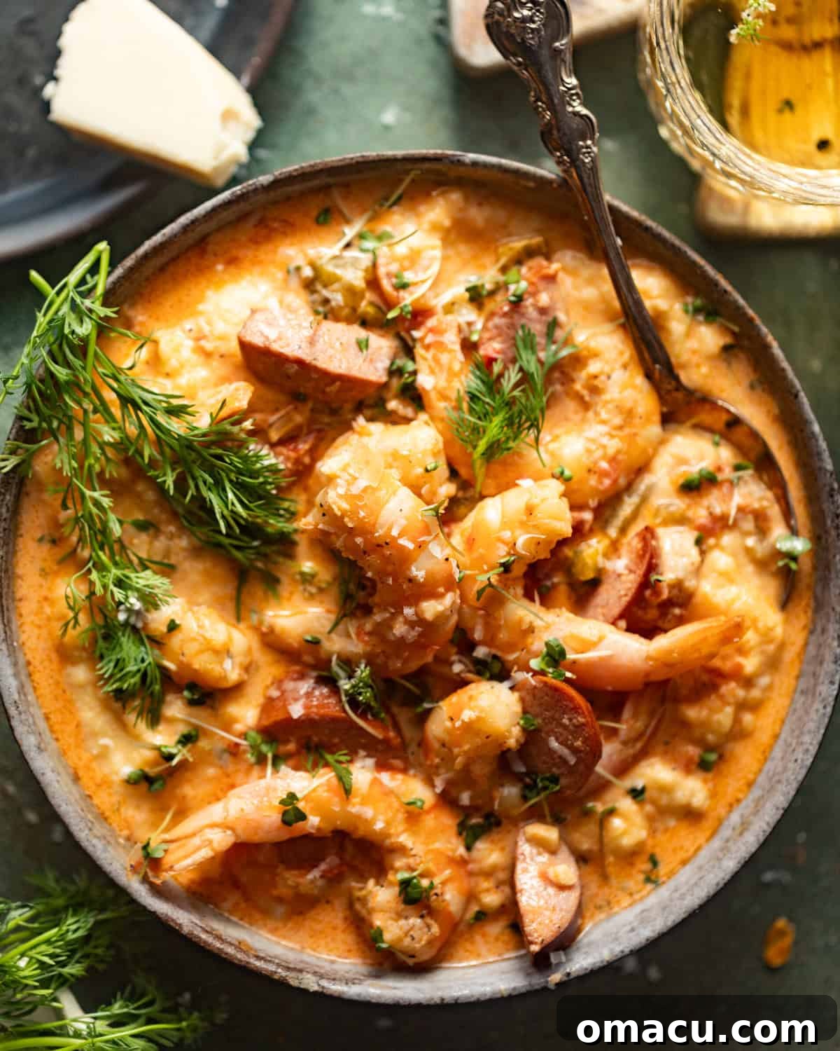 Beautifully plated cajun shrimp and grits in a bowl, garnished with fresh herbs and a sprinkle of parmesan cheese.