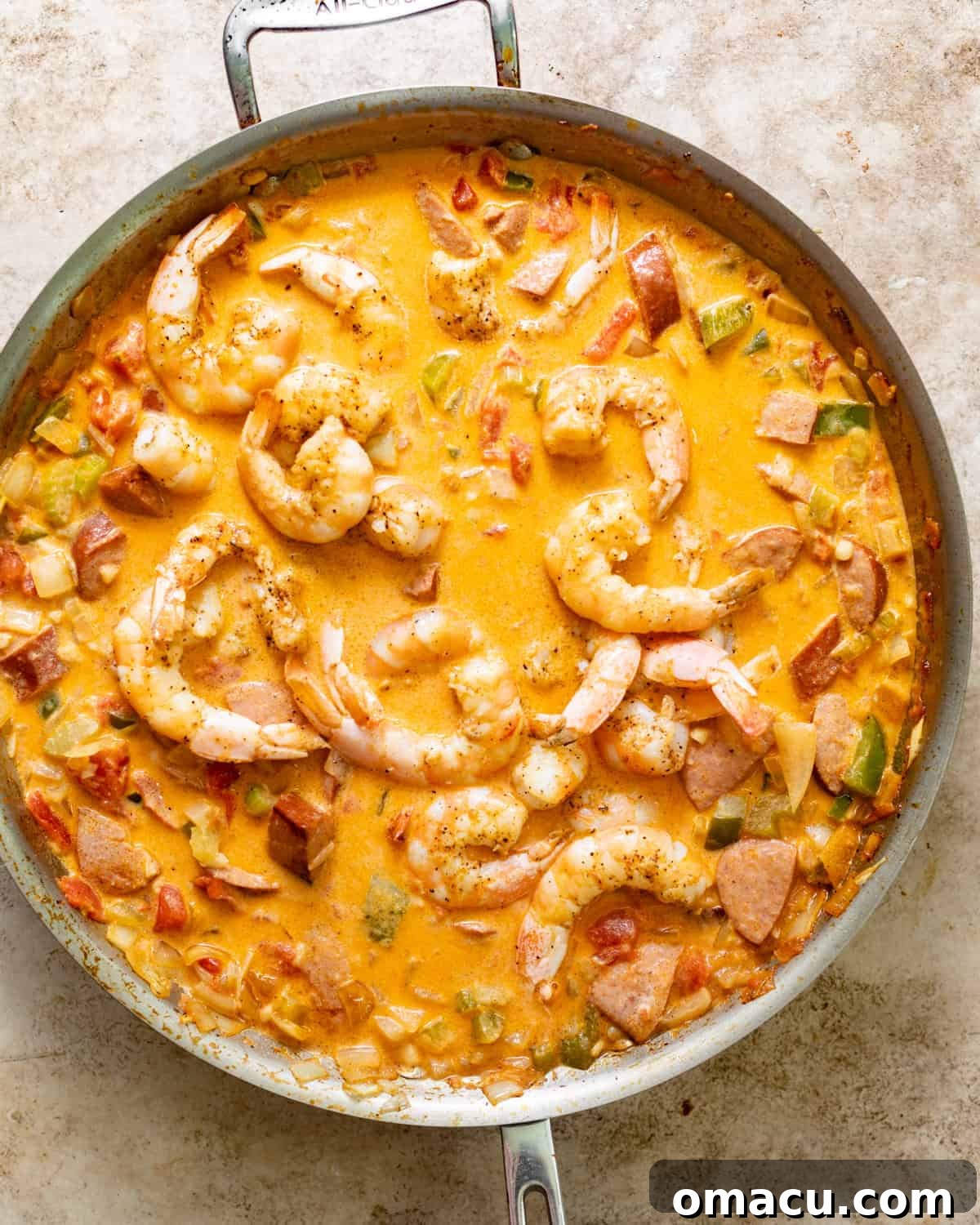 Cajun shrimp simmering in a rich, buttery sauce with vegetables in a skillet, ready to be served.