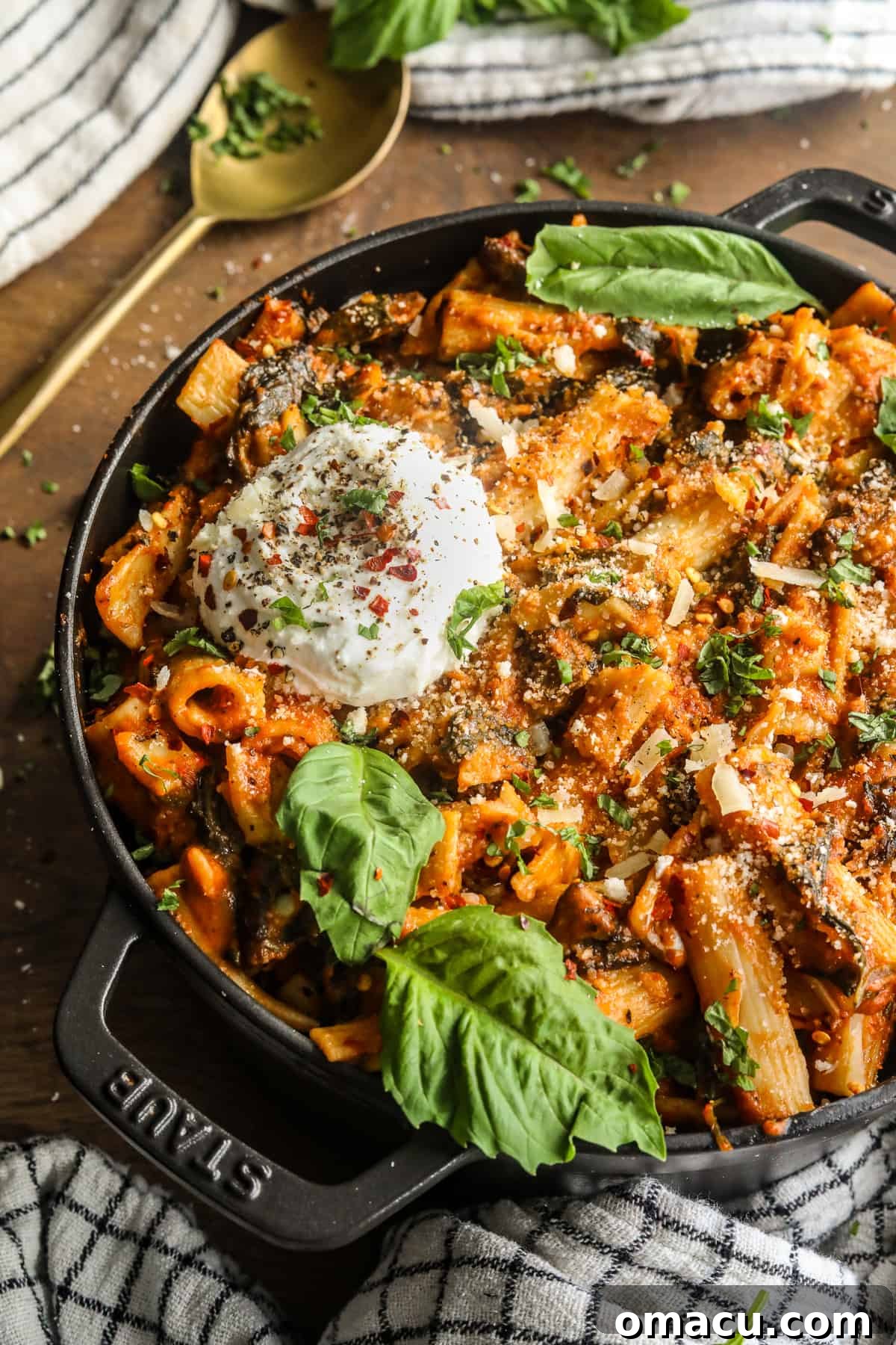 Freshly cooked one-pot creamy tomato pasta in a pot with a serving spoon, garnished with basil.