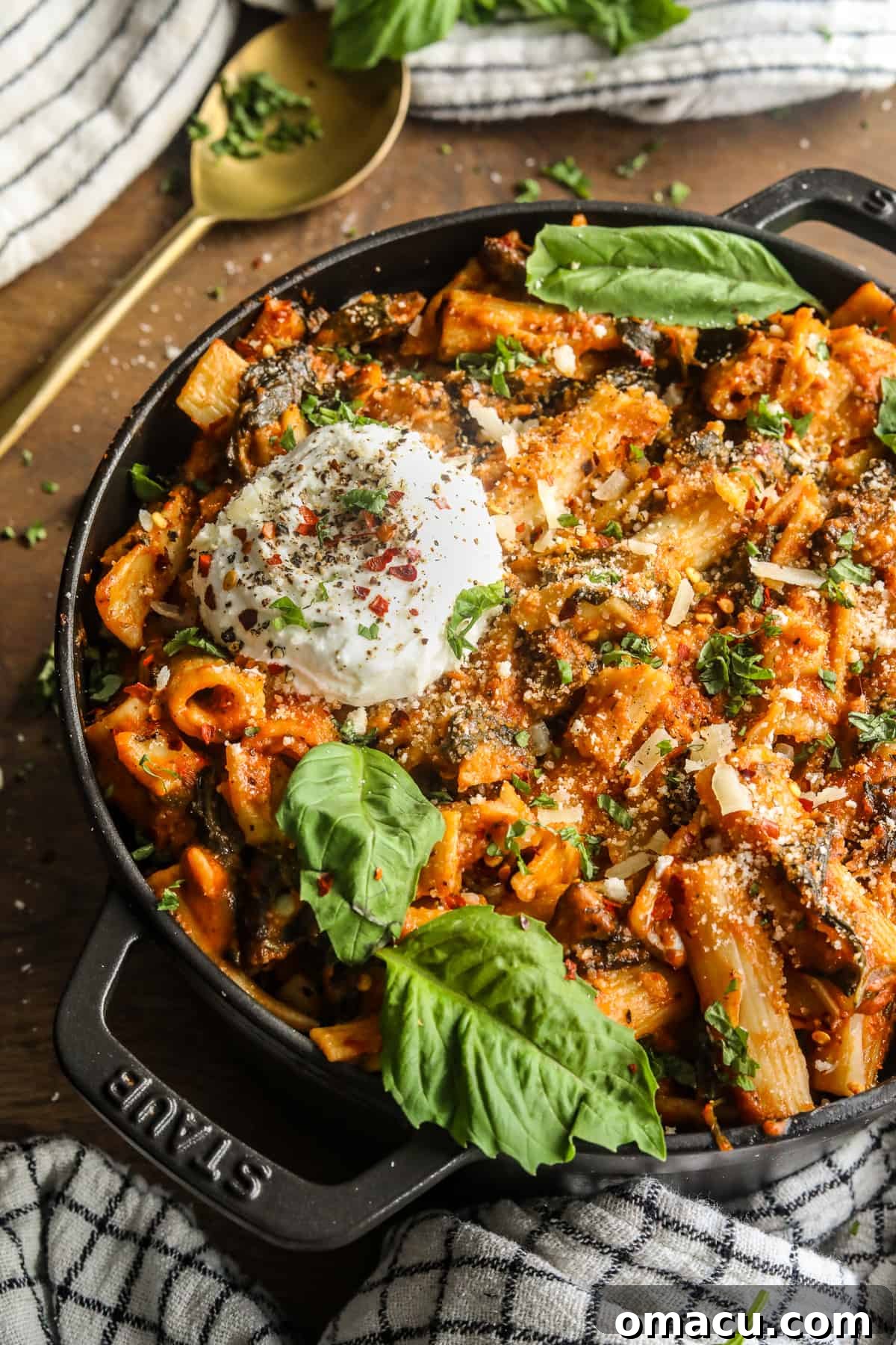 A close-up of the creamy tomato pasta with spinach and mushrooms in a rustic pot, ready for serving.