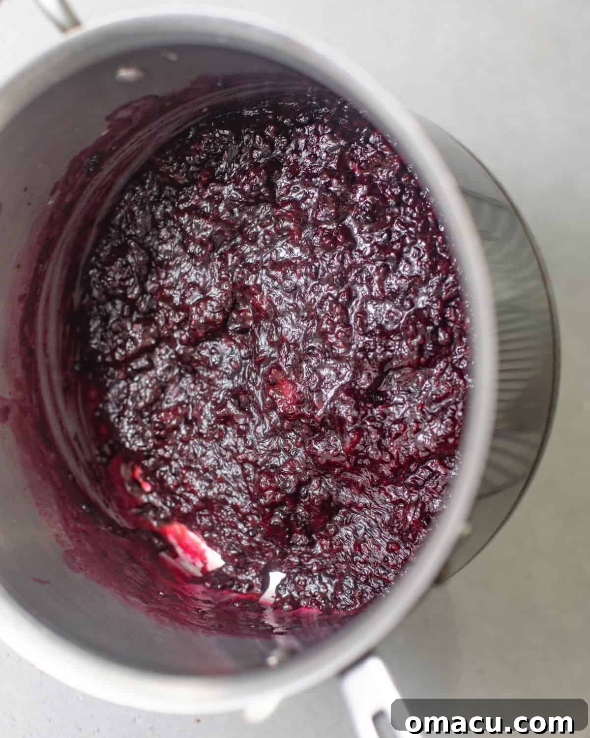 Homemade blackberry jam filling simmering in a saucepan.