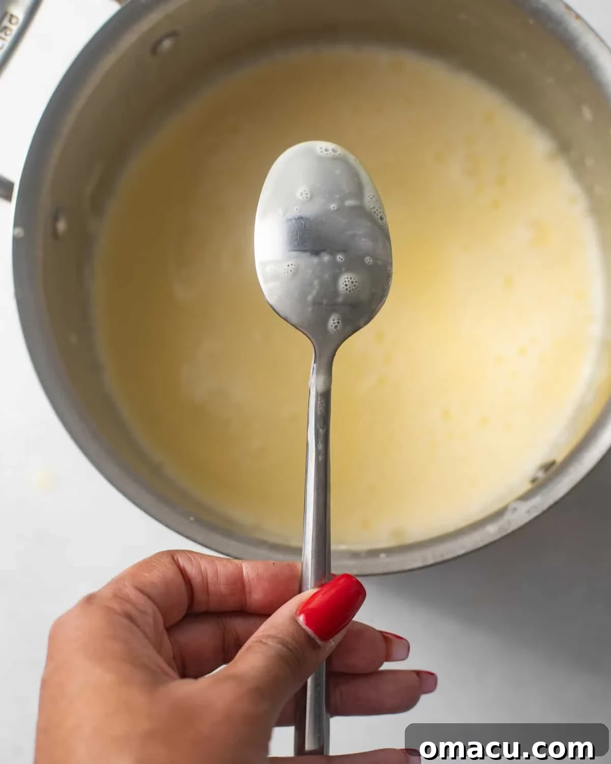 a spoon with the mousse coating the back of a spoon to show how thick the cream should be when it's finished.