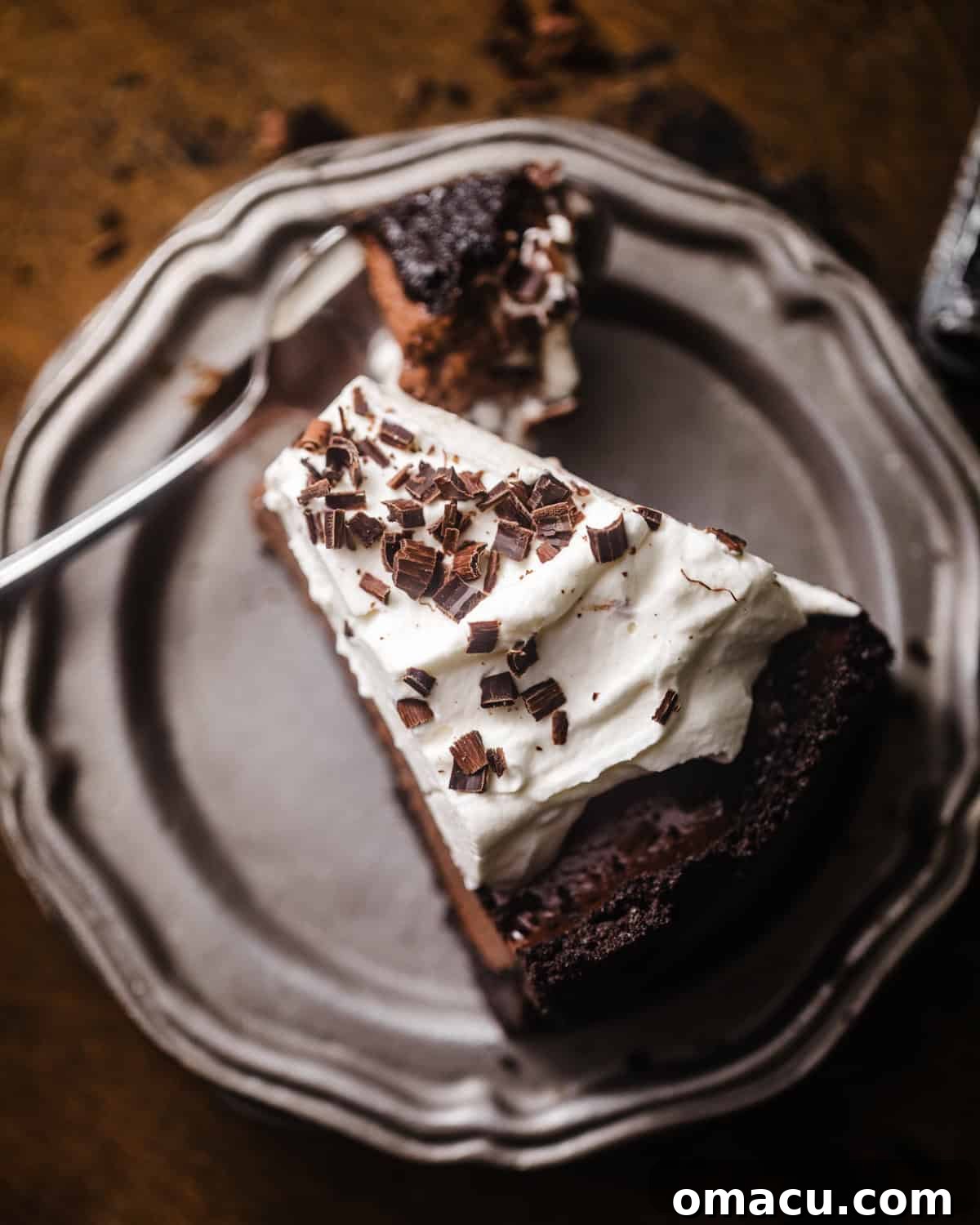 an overhead photo of chocolate mousse pie on a plate with a fork. 