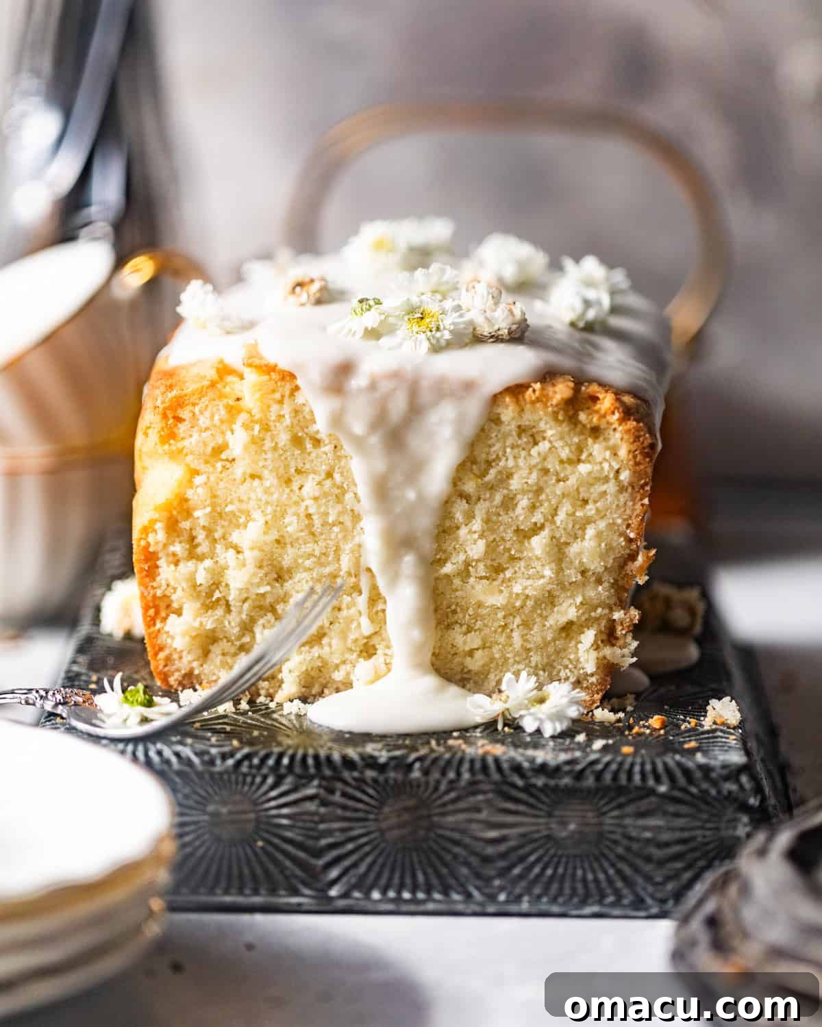 An enticing close-up of a freshly baked coconut loaf cake, beautifully sliced to reveal its incredibly moist and tender interior, rich with visible shredded coconut flakes.