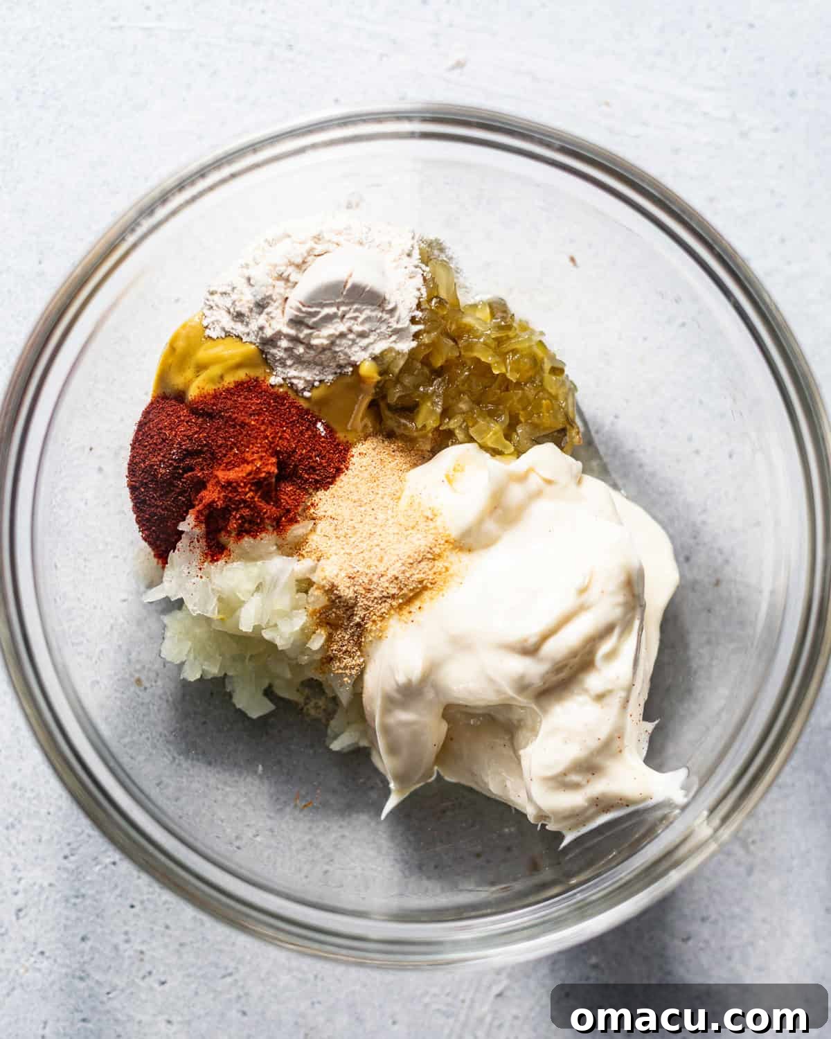 Ingredients for Big Mac Special Sauce mixed in a bowl, featuring mayo, ketchup, mustard, grated onion, relish, and various seasonings.