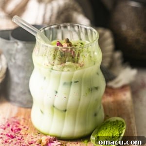 Iced matcha latte on a cutting board with a spoonful of matcha.