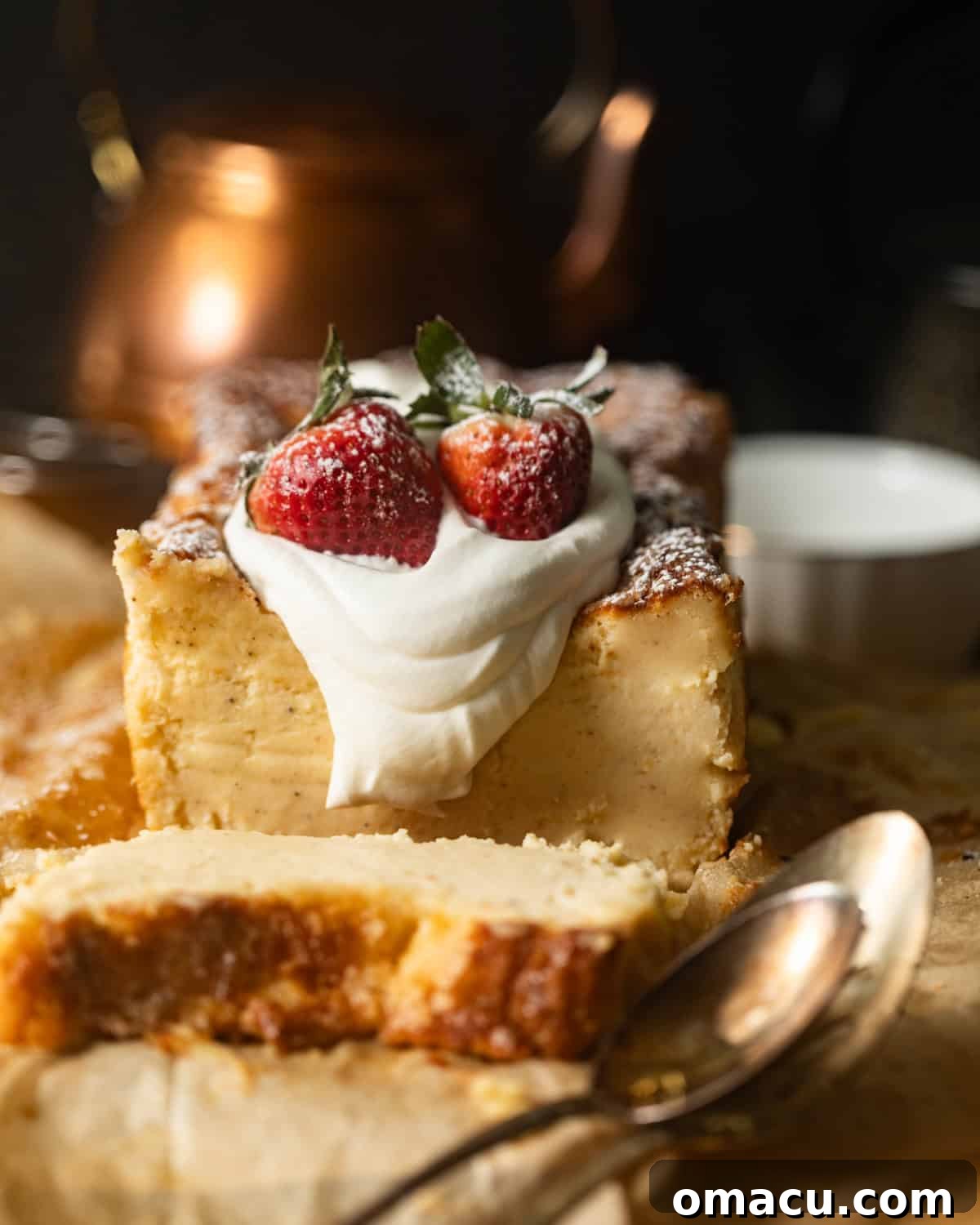 A beautifully caramelized loaf pan Basque cheesecake on parchment paper, adorned with fresh whipped cream and vibrant strawberries.