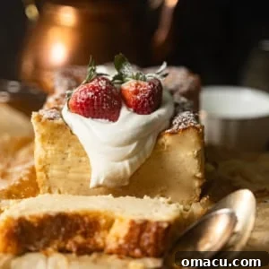 Loaf pan Basque cheesecake on parchment paper, topped with whipped cream and strawberries.