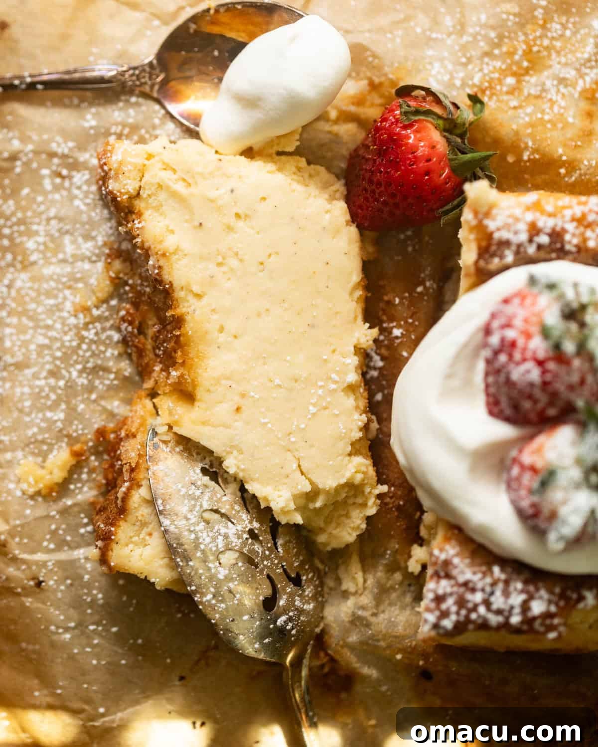 A delectable slice of loaf pan Basque cheesecake adorned with fresh strawberries and a dollop of whipped cream, presented on parchment paper.