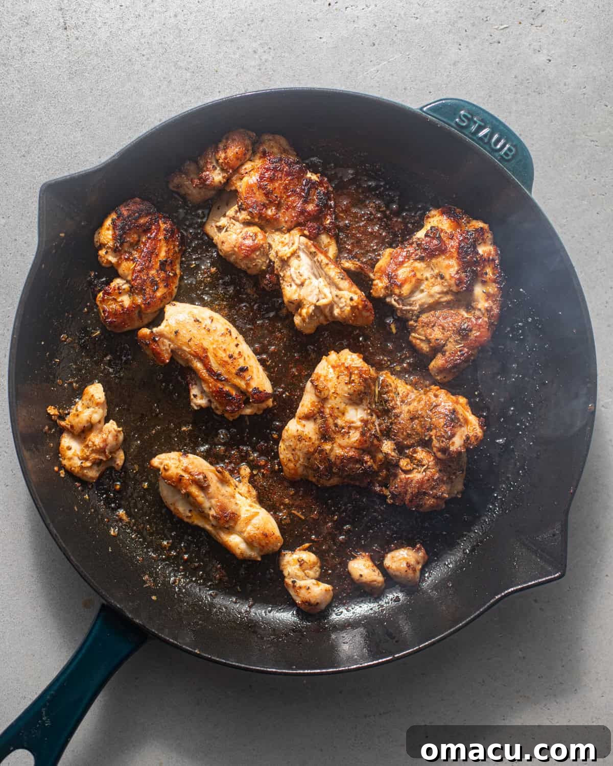 Seared golden-brown chicken thighs in a large skillet.