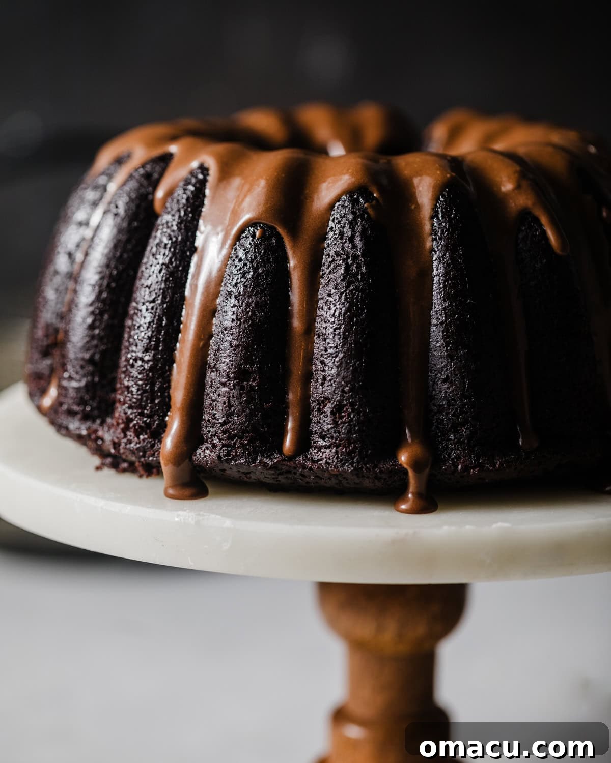 Decadent Chocolate Donut Cake on a pristine cake stand, adorned with a luscious chocolate glaze, ready to be enjoyed.