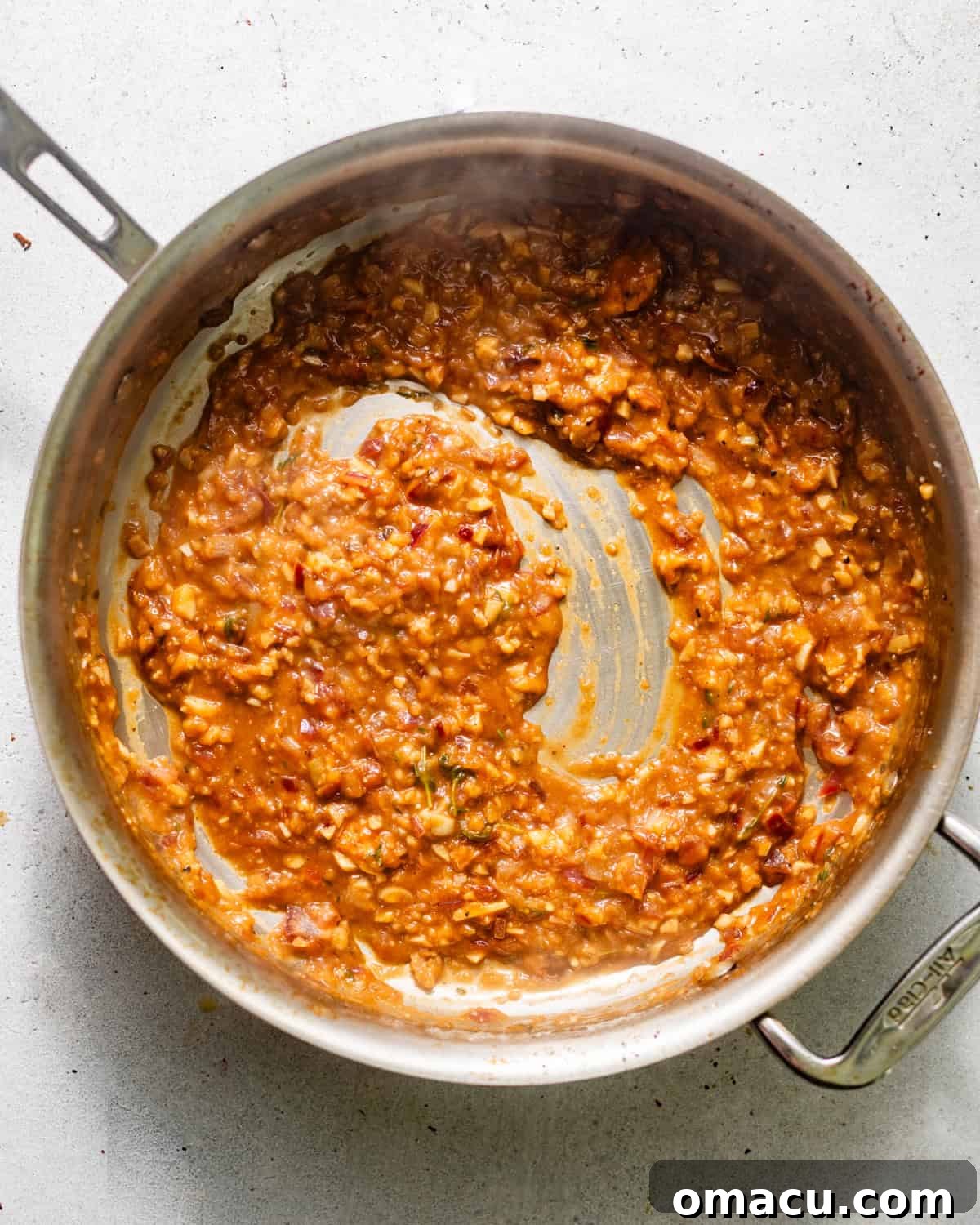 Shallots, garlic, white wine, and fresh thyme simmering in a skillet, creating a flavorful base for the sauce.