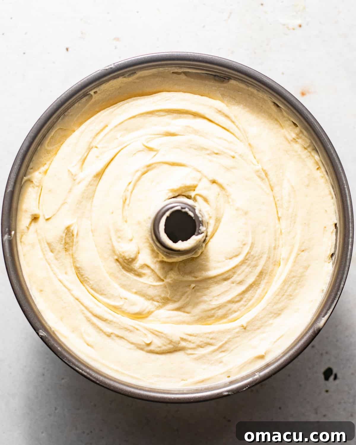 Mascarpone pound cake batter poured into a greased bundt pan, ready for baking.